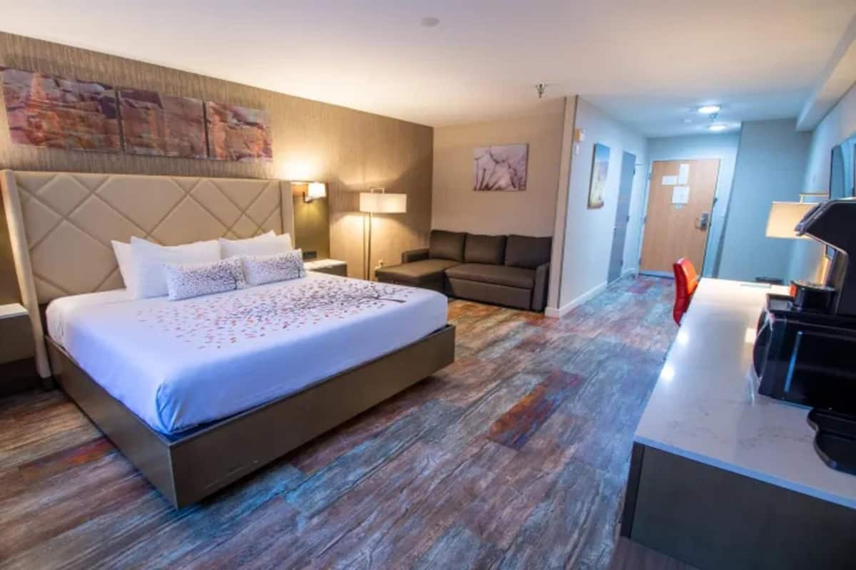Une chambre d’hôtel avec un grand lit, un bureau, un canapé et une télévision.