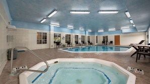 A swimming pool area with two pools, a diving board, and a seating area with tables and chairs. - Comfort Inn & Suites Fenton (Fenton)