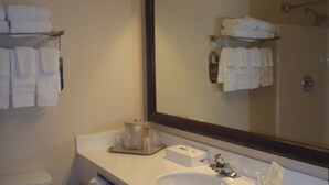 A bathroom with a white sink, a mirror, and a towel rack with folded towels. - Comfort Inn & Suites Dayville - Killingly Industrial Park (Dayville)