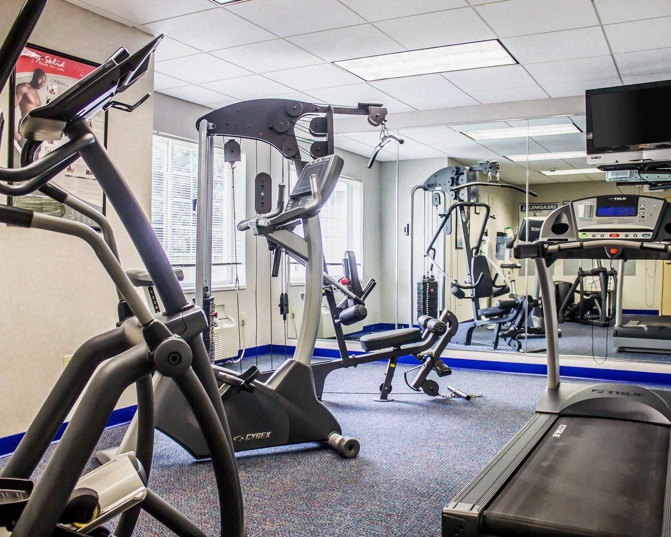 A gym with various exercise equipment including treadmills, a stationary bike, and weight machines.