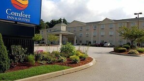 A Comfort Inn & Suites hotel with a well-maintained garden and a clear view of the building's entrance.