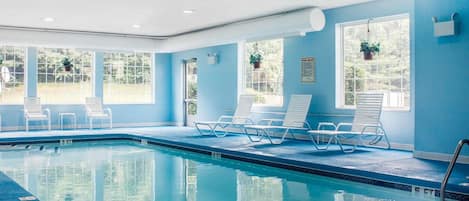 Una piscina techada, sillones reclinables de piscina