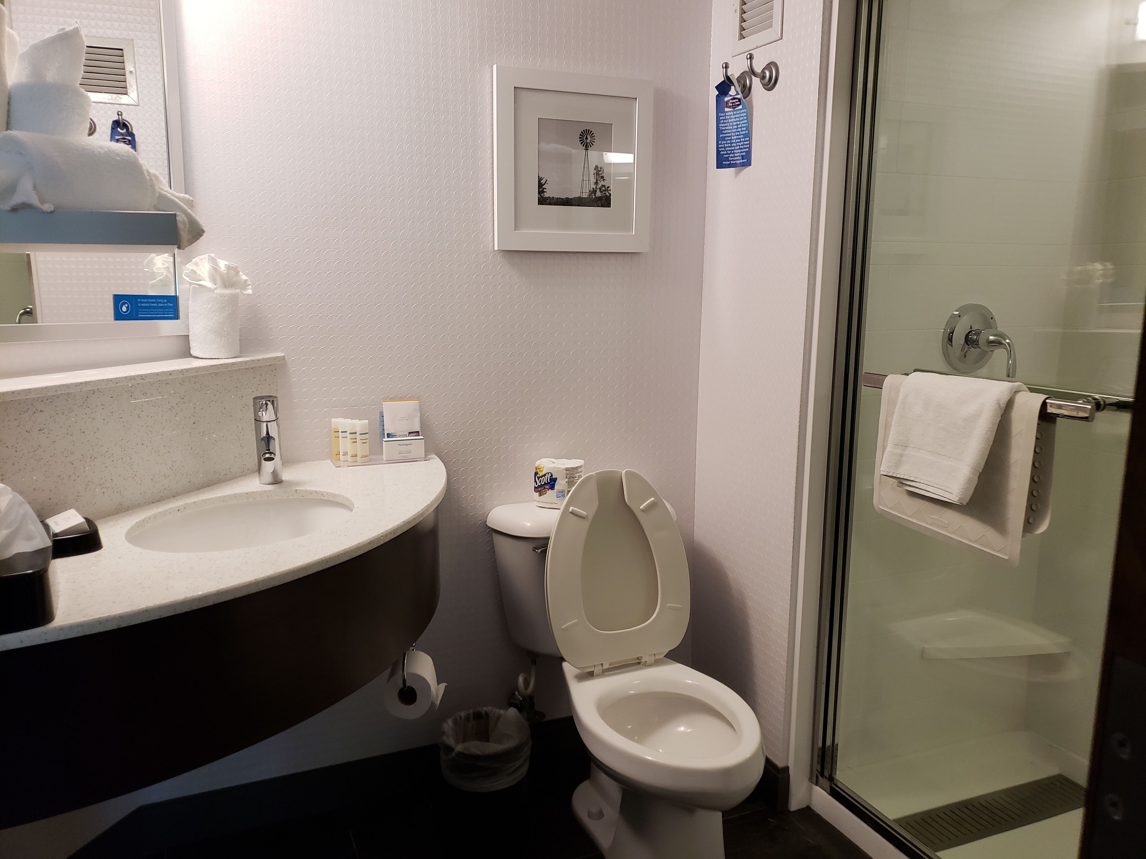 Kylpyhuoneessa on kaksi pesuallasta, wc ja lasinen suihkukaappi.