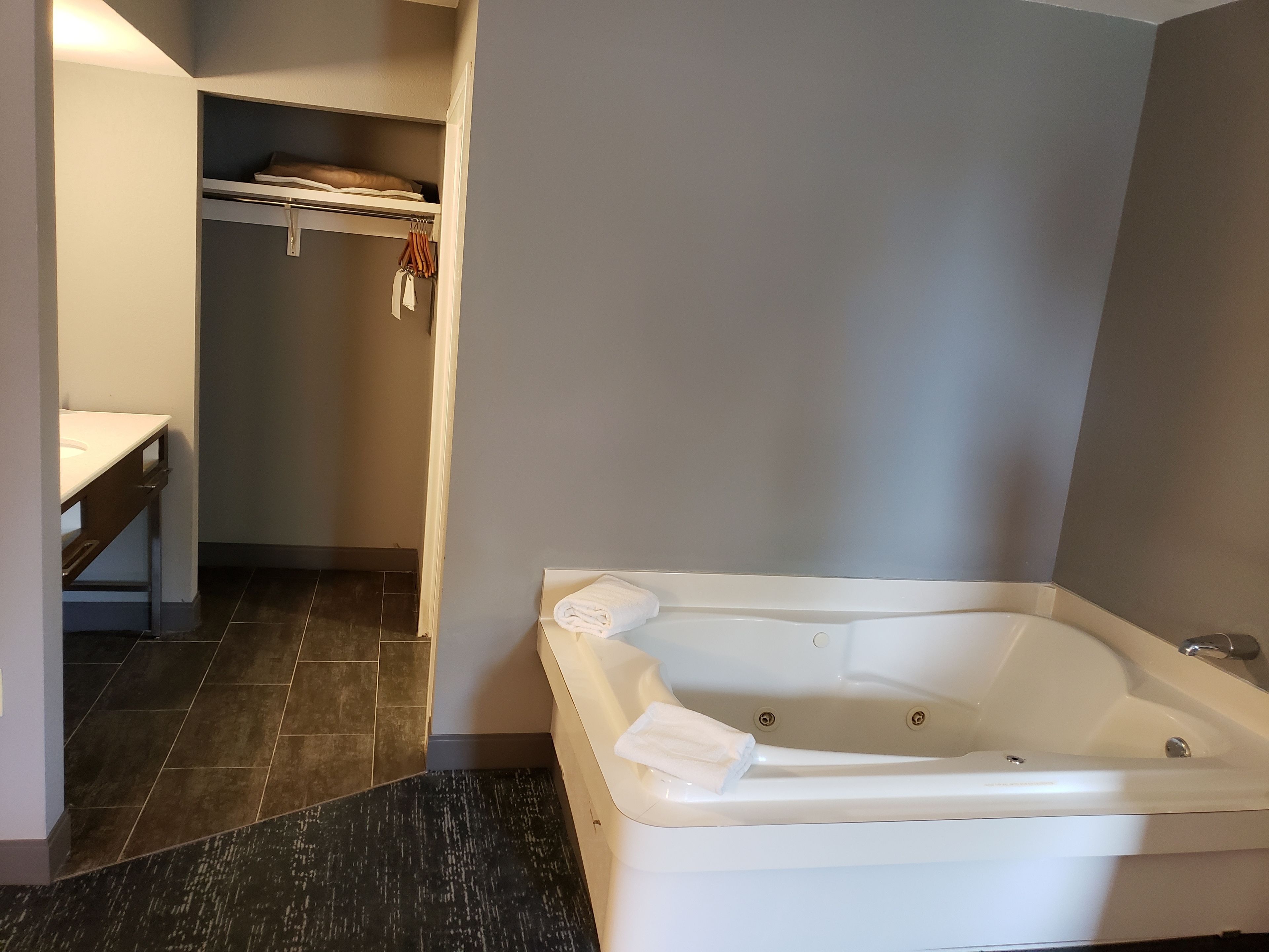 A modern bathroom with a bathtub, a vanity with a sink, and a towel rack.