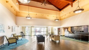 A spacious lobby with a reception desk, seating area, and large windows. - Hampton Inn & Suites Newtown (Morrisville)
