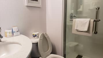 Un baño con inodoro, lavamanos y cabina de ducha de vidrio.