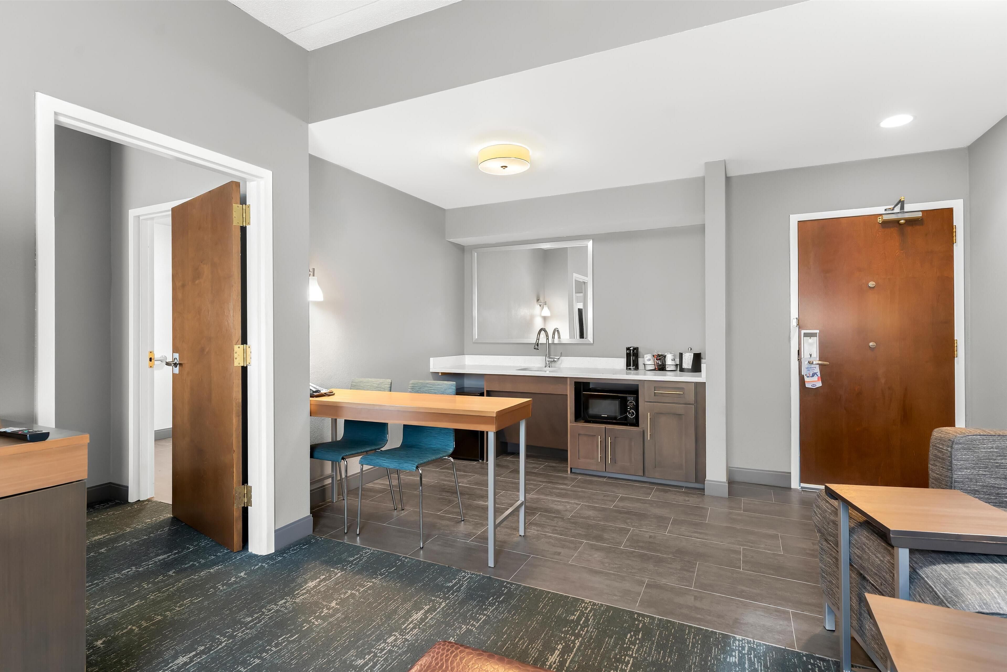 A modern kitchen with a dining area, a microwave, and a sink.