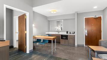 A modern kitchen with a dining area, a microwave, and a sink.