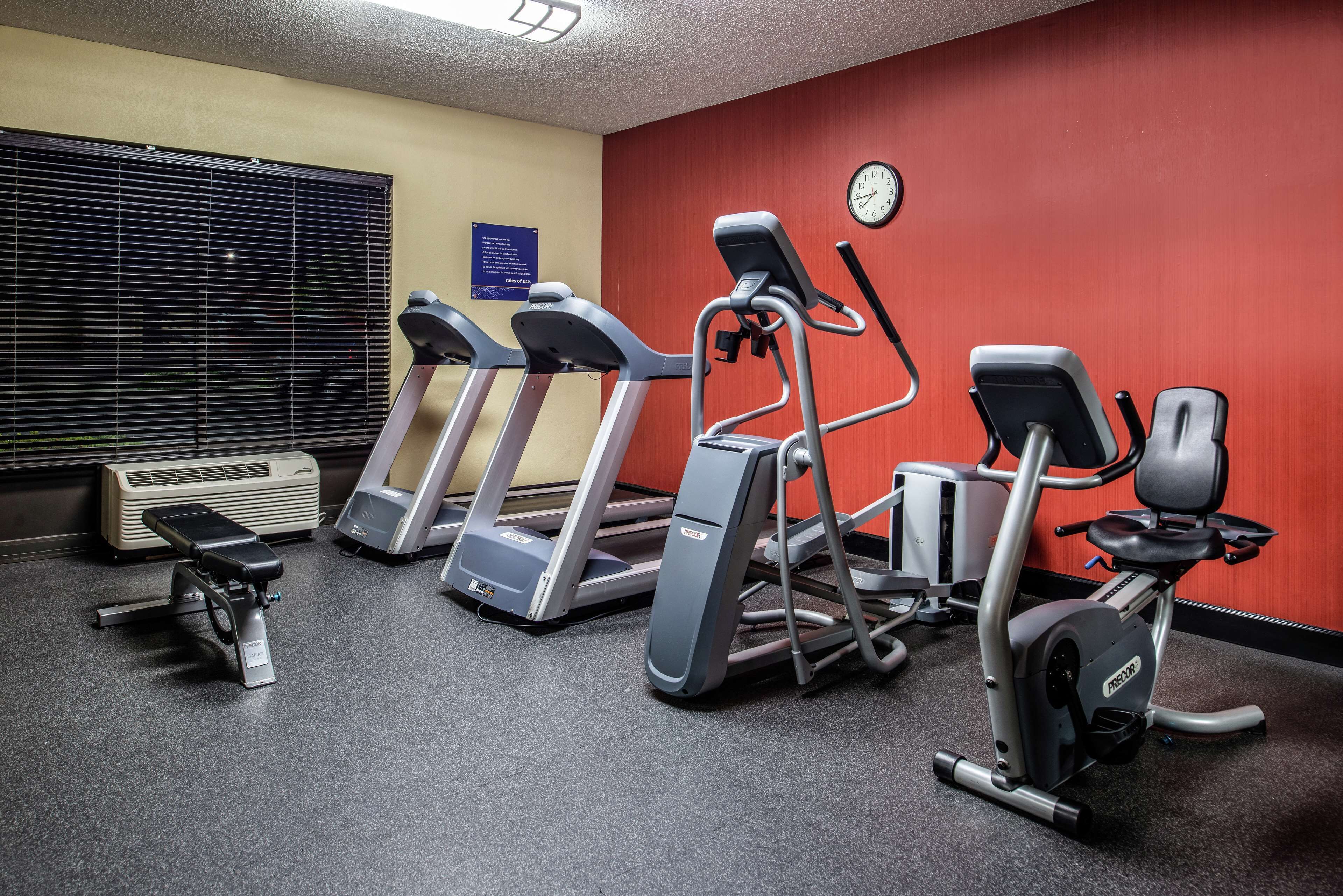 Une salle de sport équipée de tapis de course, d’un vélo elliptique et d’un vélo d’appartement.