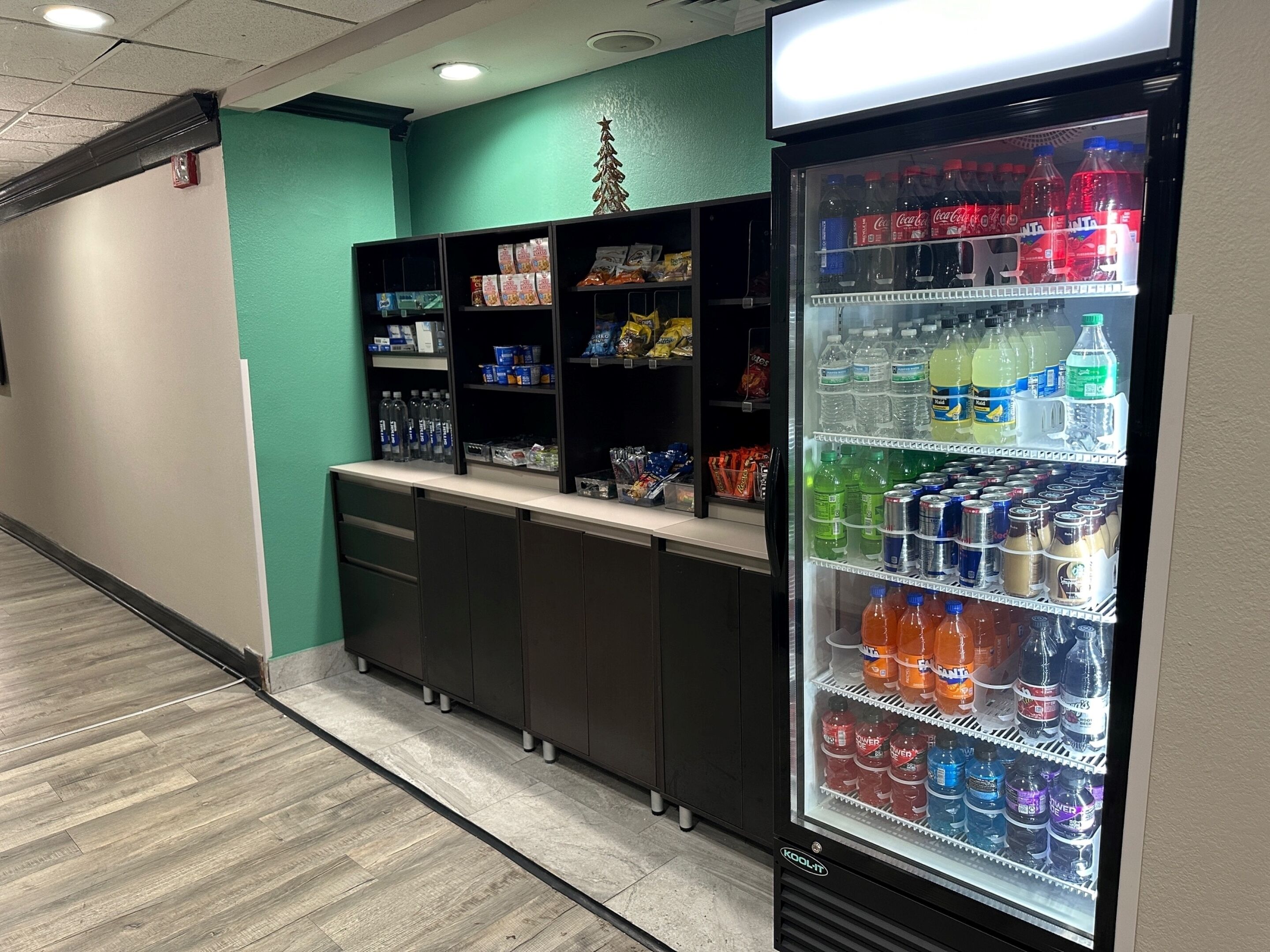 A vending area with a variety of drinks and snacks, including bottled water, sodas, and packaged foods.