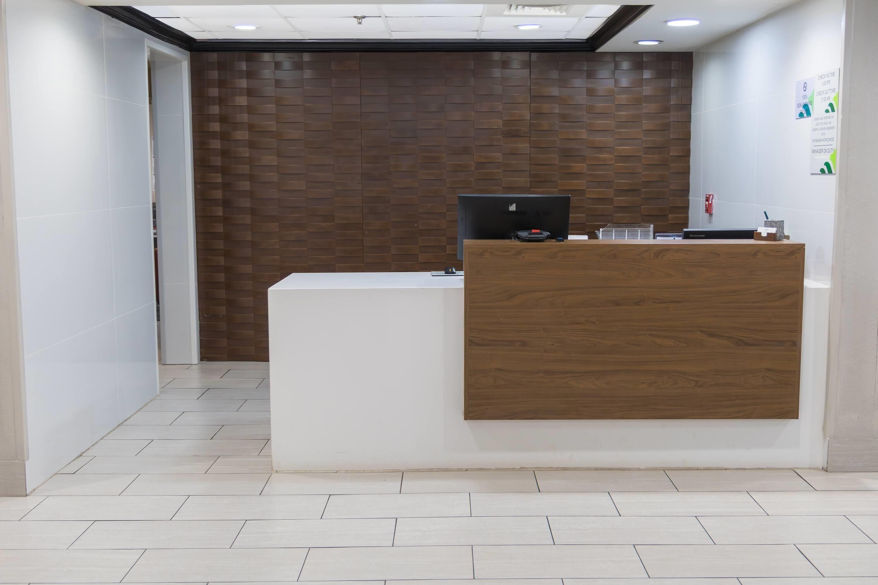 A reception desk with a computer, a telephone, and a small counter.