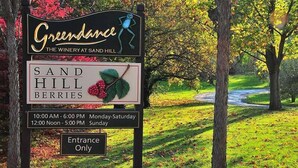A sign for Greendale The Winery at Sand Hill with operating hours and an entrance-only notice.
