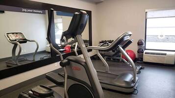 A gym with treadmills, a stationary bike, and a rowing machine.