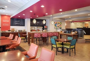 Un restaurante con barra, asientos y cocina.