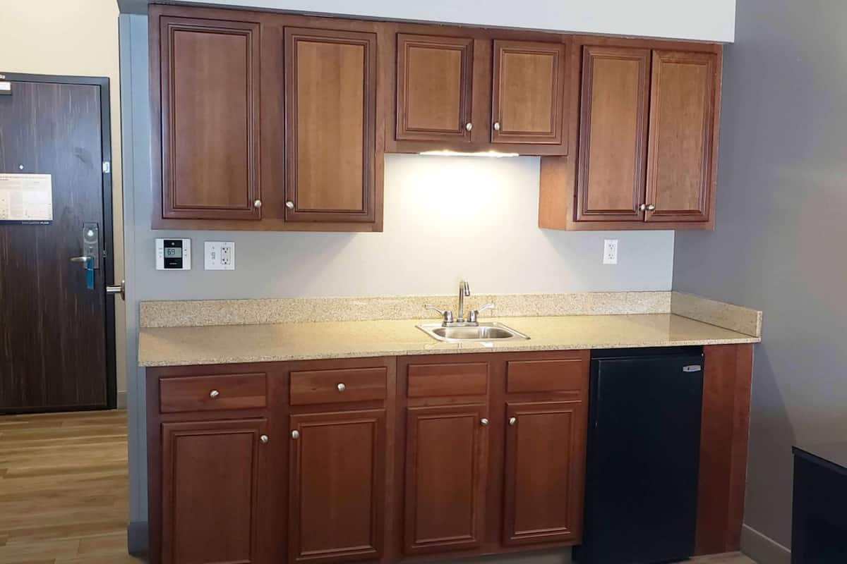 A kitchen with wooden cabinets, a stainless steel sink, and a dishwasher.