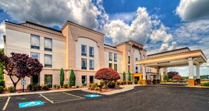 A hotel with a parking lot, a gas station, and a clear sky. - Hampton Inn Greensburg (Greensburg)