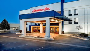 A modern Hampton Inn hotel with a prominent entrance, a covered outdoor area, and a clear sky. - Hampton Inn Longmont (Longmont)