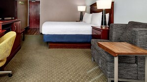 A hotel room with a bed, a desk, a chair, a TV, and a lamp. - Hampton Inn Longmont (Longmont)