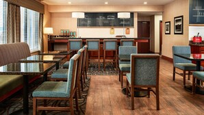 A hotel lobby with a seating area, a counter with a chalkboard menu, and a coffee station. - Hampton Inn Longmont (Longmont)