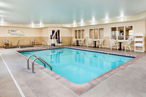 Una piscina techada, sillones reclinables de piscina