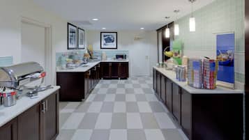 Una cocina moderna con piso a cuadros, microondas, tostadora y cafetera.