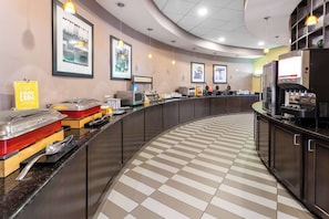 A breakfast bar with a checkered floor, a coffee machine, and a sign labeled "EGGS".