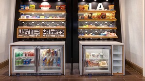Un présentoir proposant divers types de chips et un espace réfrigéré pour les boissons.
