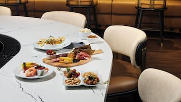 Une table à manger, dressée avec différents plats, entourée de chaises en cuir.