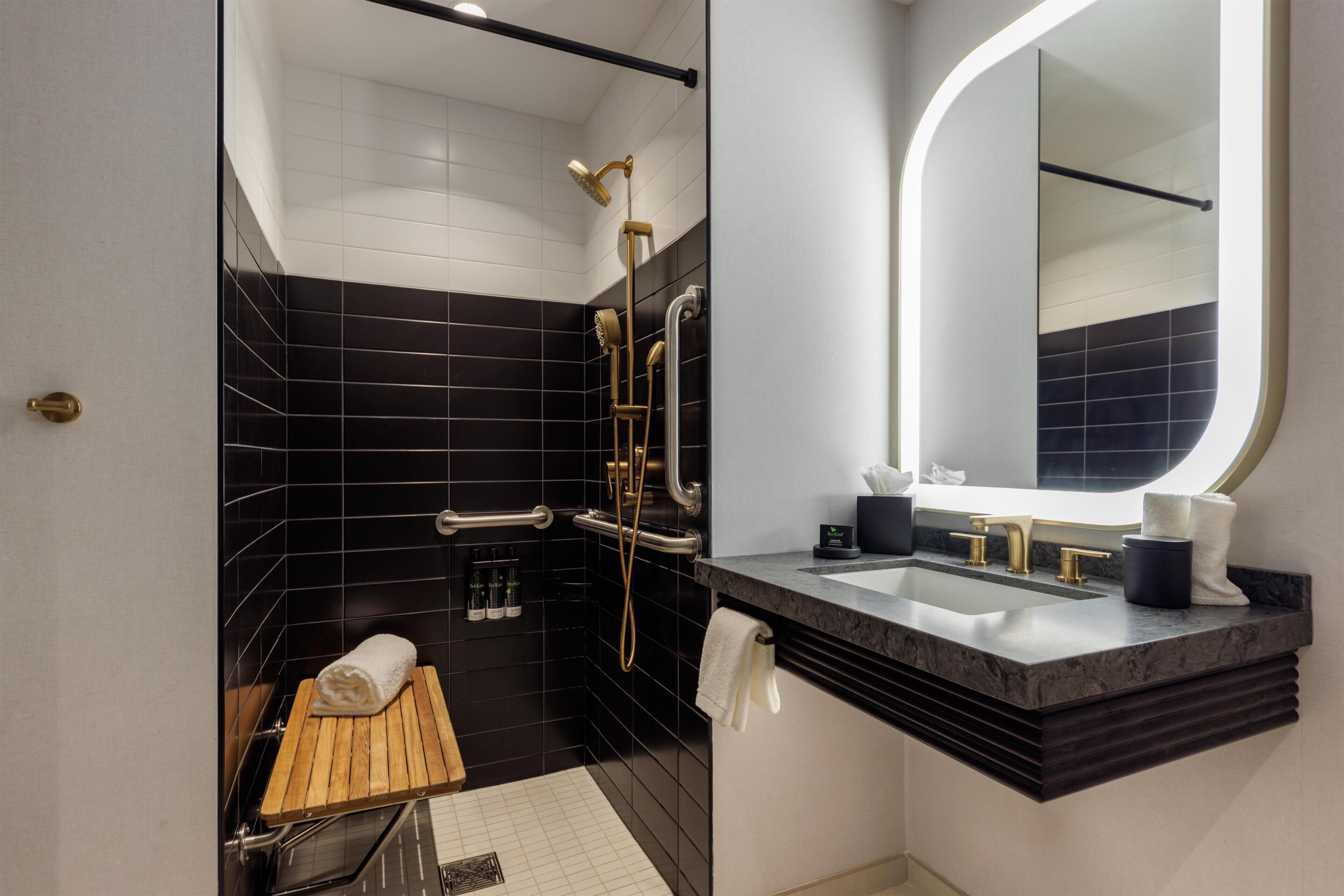Un baño moderno con ducha, tocador y espejo.