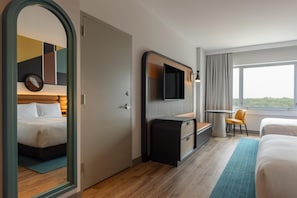 A hotel room with a bed, a desk, a chair, a TV, and a window with a view. - Hyatt Centric Chicago O'Hare (Rosemont)