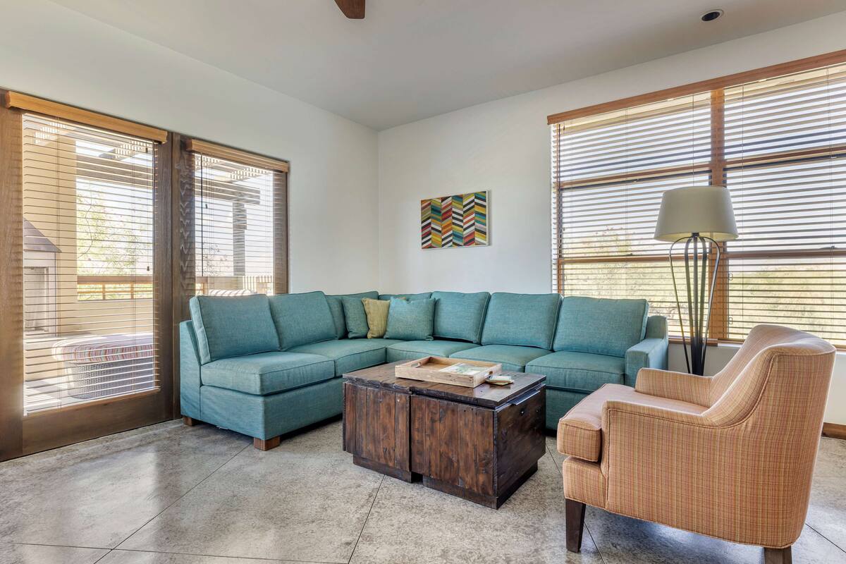 A living room with a sectional sofa, a wooden coffee table, and a chair.