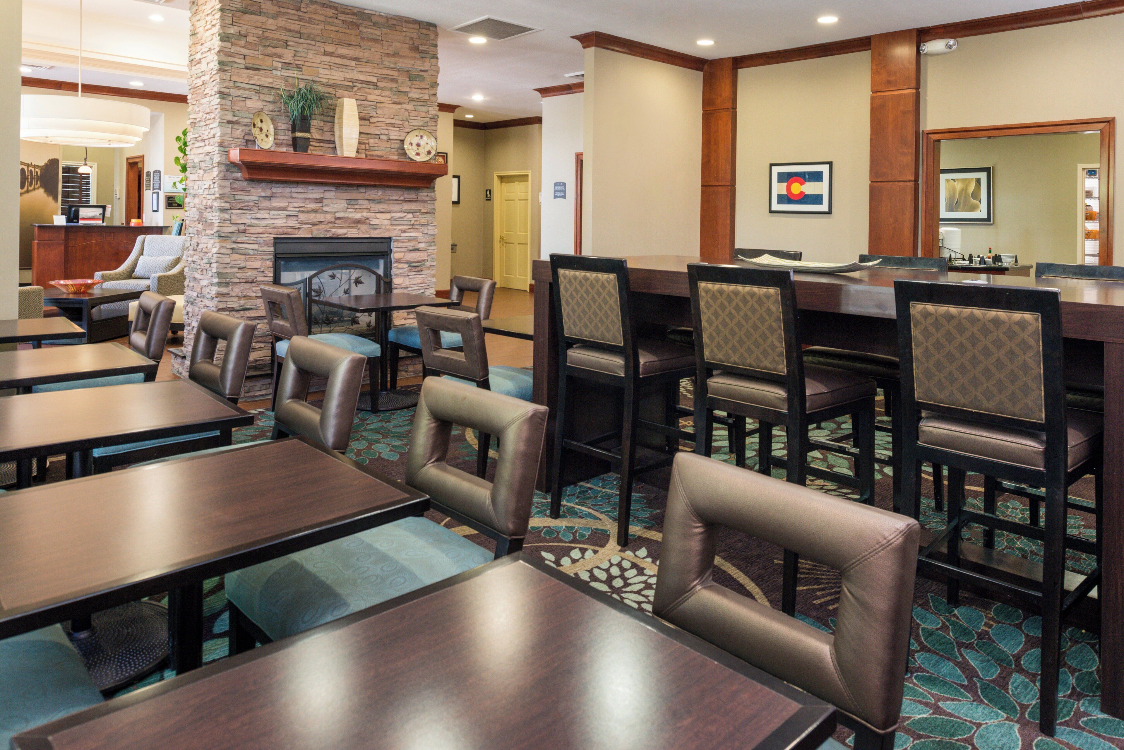 A hotel lobby with a stone wall, seating area, and a reception desk.