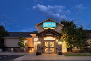 Un hotel Staybridge Suites con cartel, entrada y pilares de piedra.