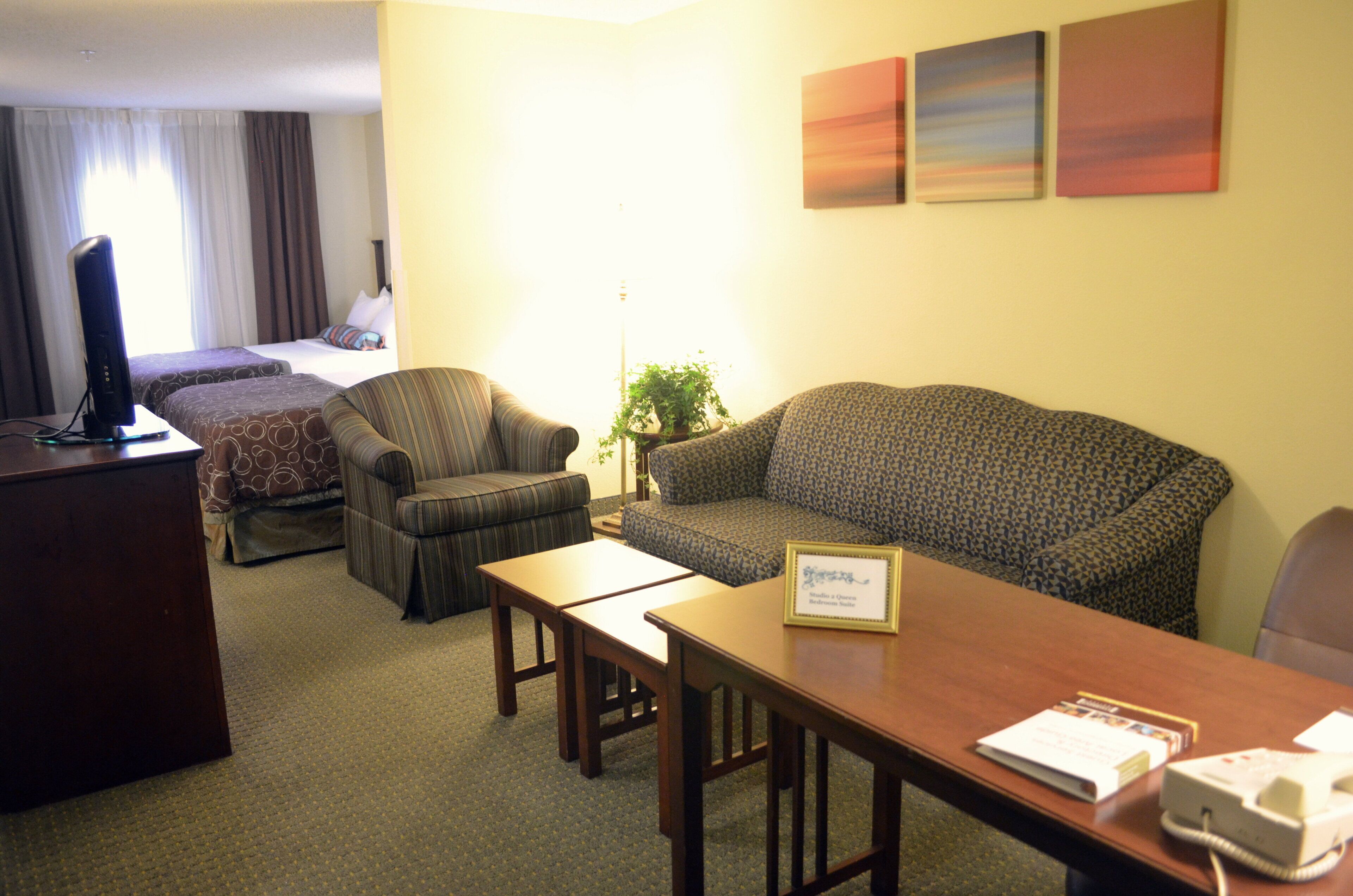 A hotel room with a bed, two armchairs, a sofa, a desk, and a telephone.