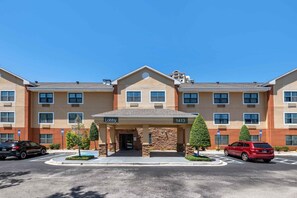 A multi-story hotel with a central lobby, parking lot, and a clear blue sky. - Extended Stay America Suites Jacksonville Riverwalk Conv Ctr (Jacksonville)