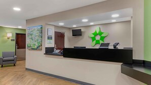 Una recepción con un logotipo verde, un cuadro y una mesa de registro.
