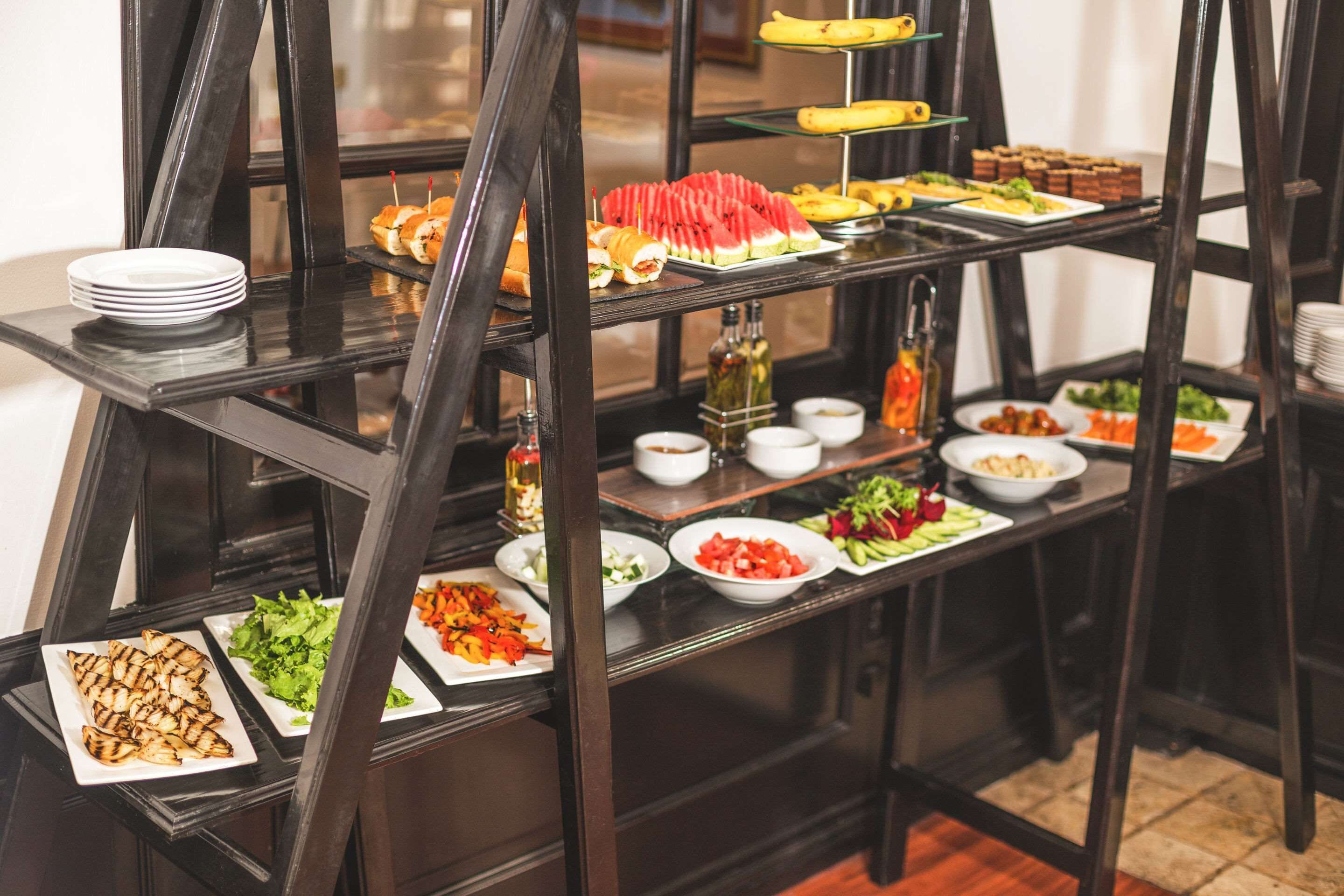 A buffet setup with various food items and condiments on multiple shelves.