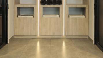 Un interior moderno con estanterías de madera, algunas con toallas enrolladas y otras con sombreros negros.