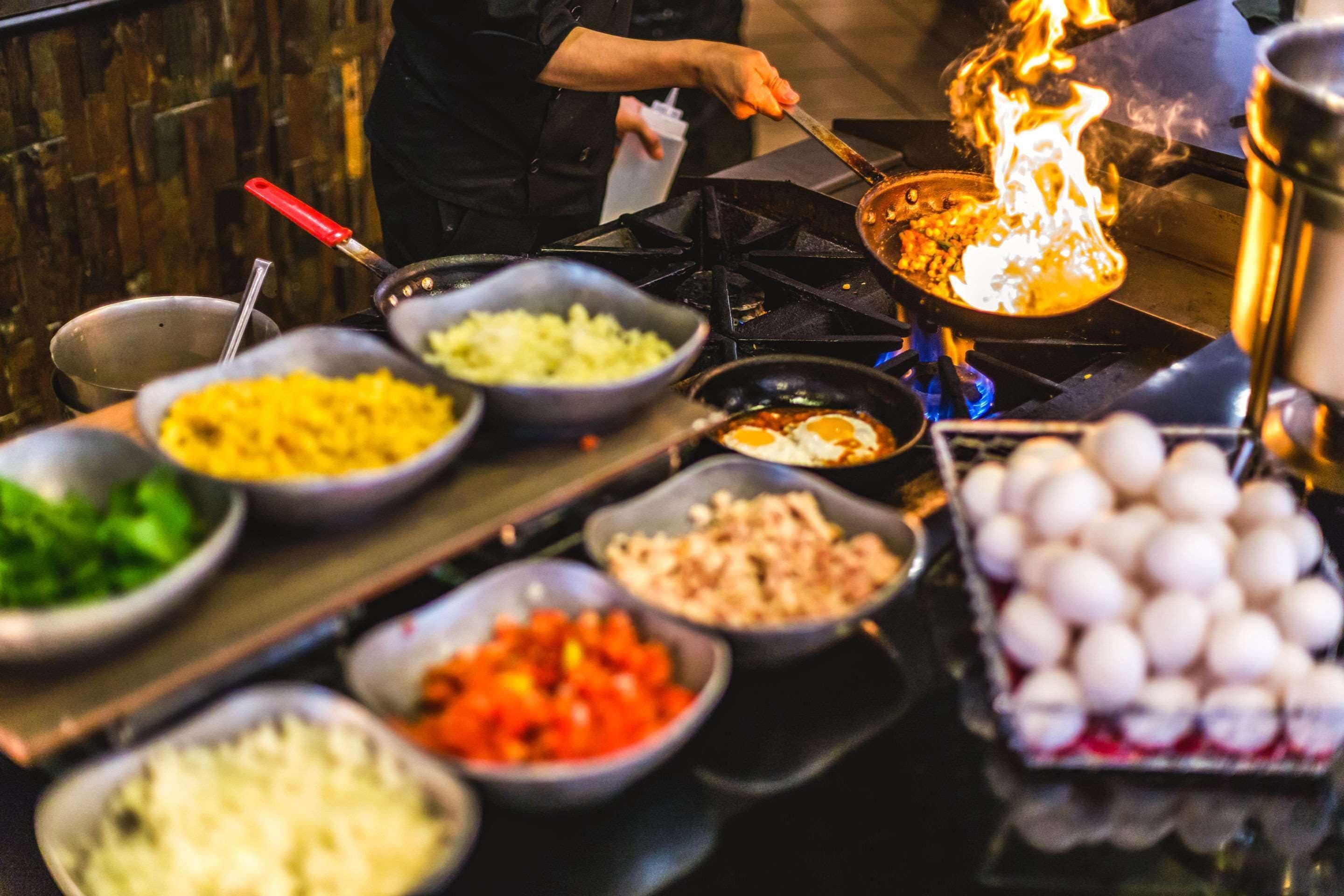 A variety of food items on a table, including bowls of rice, vegetables, and eggs.