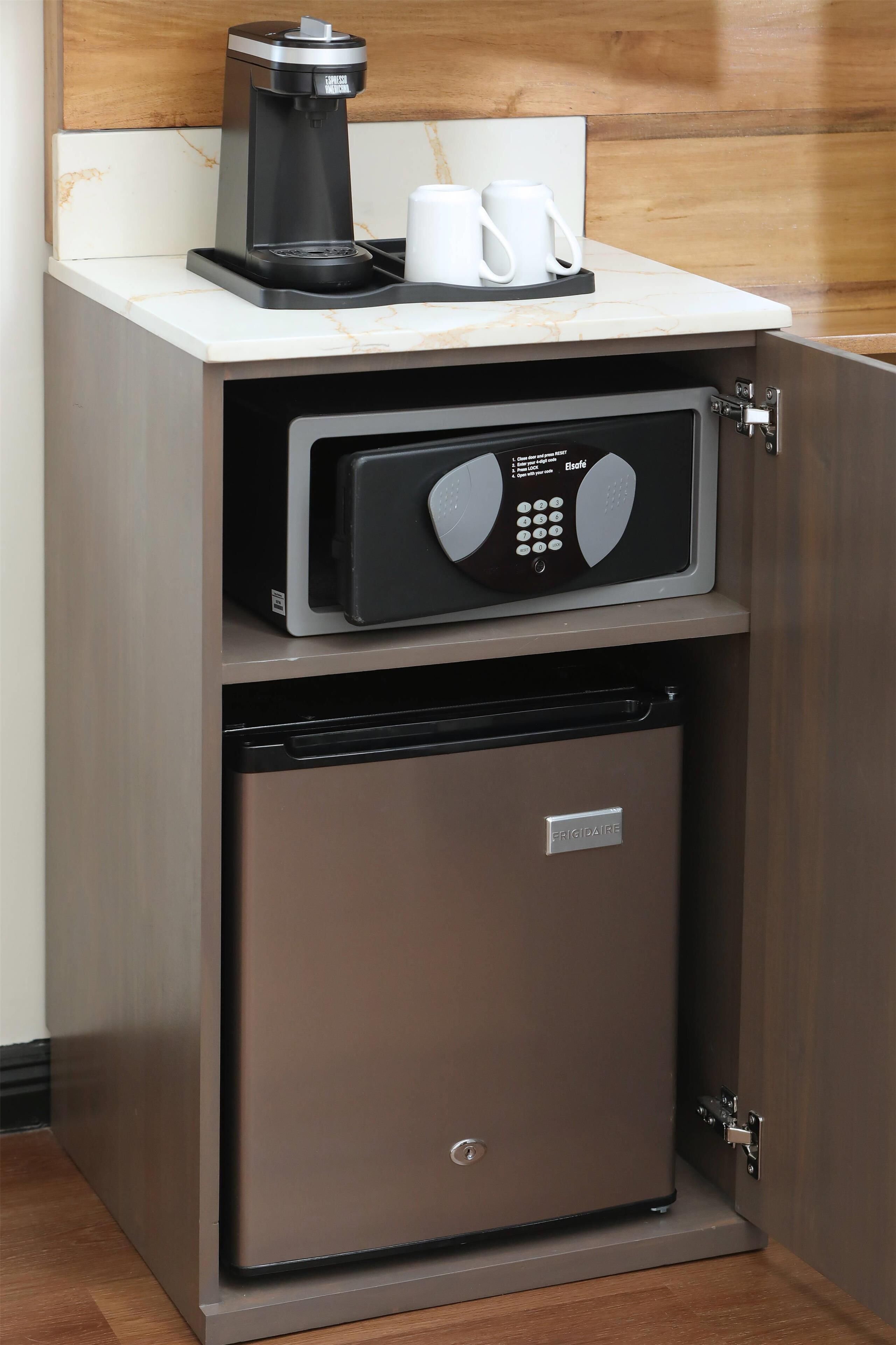 A compact kitchen with a coffee maker, a microwave, and a mini-fridge.