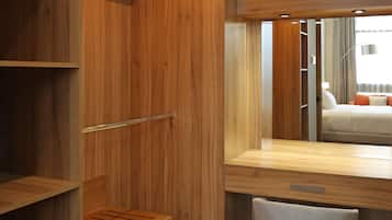 A wooden vanity with a mirror, a towel, and a shelf.