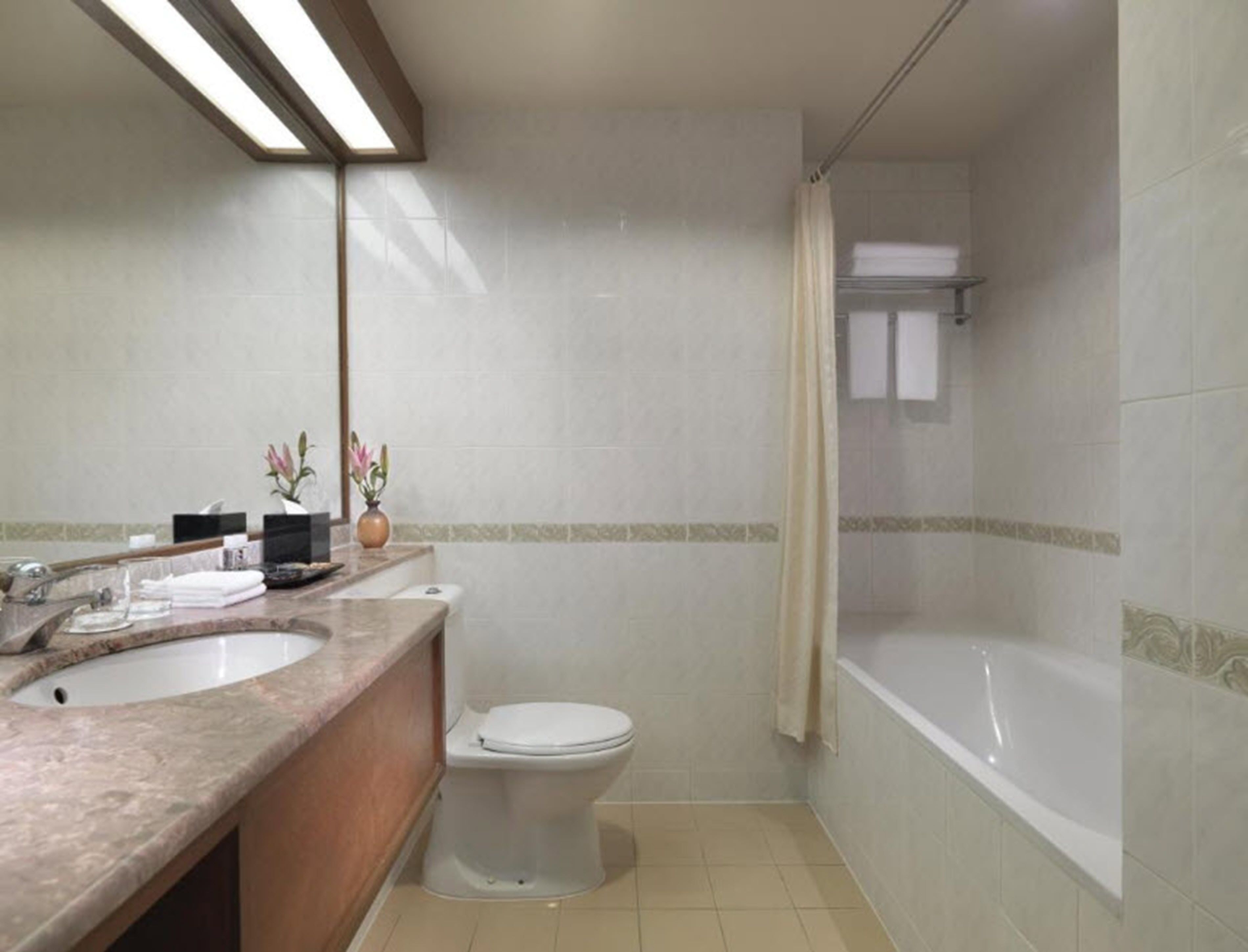 A bathroom with two sinks, a toilet, and a bathtub.