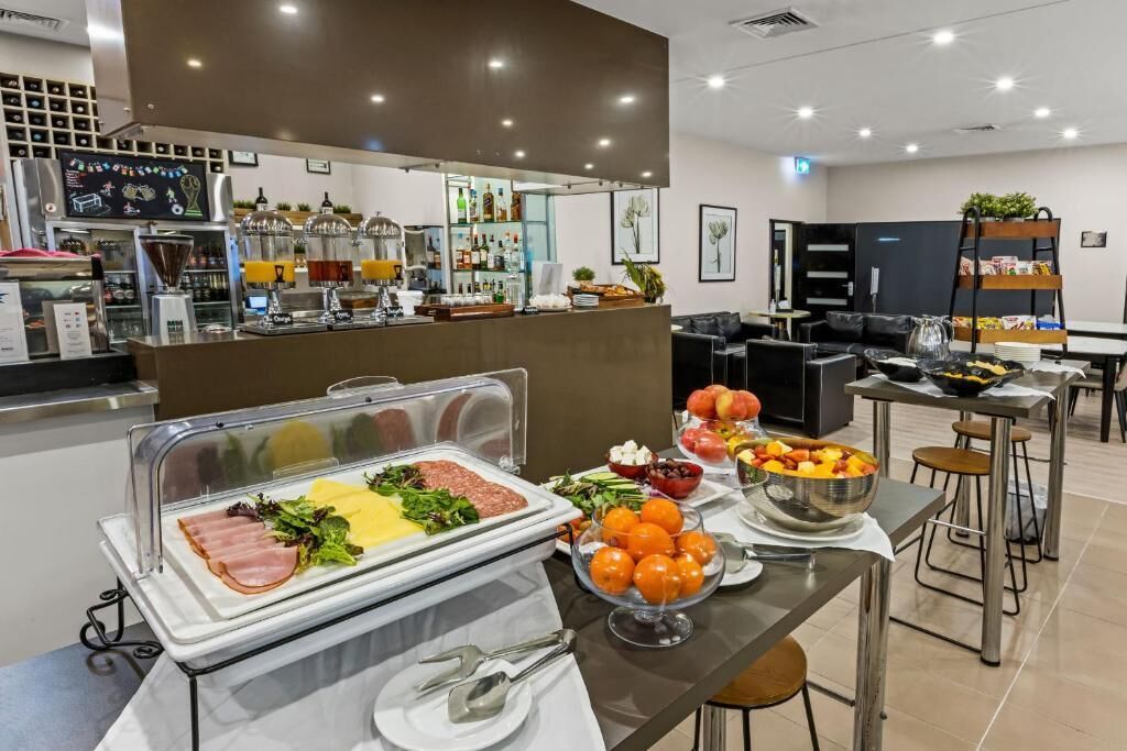 Un área de bufé con diversas opciones de comida, incluyendo carnes, ensaladas y frutas.