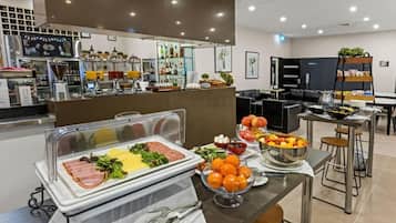 Un área de bufé con diversas opciones de comida, incluyendo carnes, ensaladas y frutas.