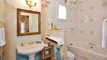 Un bagno con uno specchio grande, un lavandino, una vasca e un water.