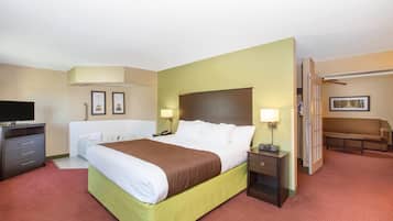 A hotel room with a bed, bedside tables, a TV, a desk, and a chair.