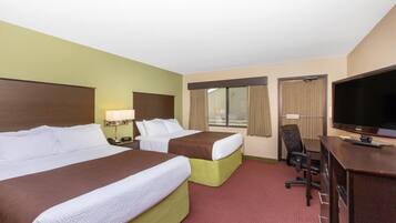 A hotel room with two beds, a desk with a TV, and a chair.