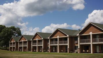Stunning hotel with a symmetrical facade, featuring balconies on each floor and a beautifully manicured lawn.