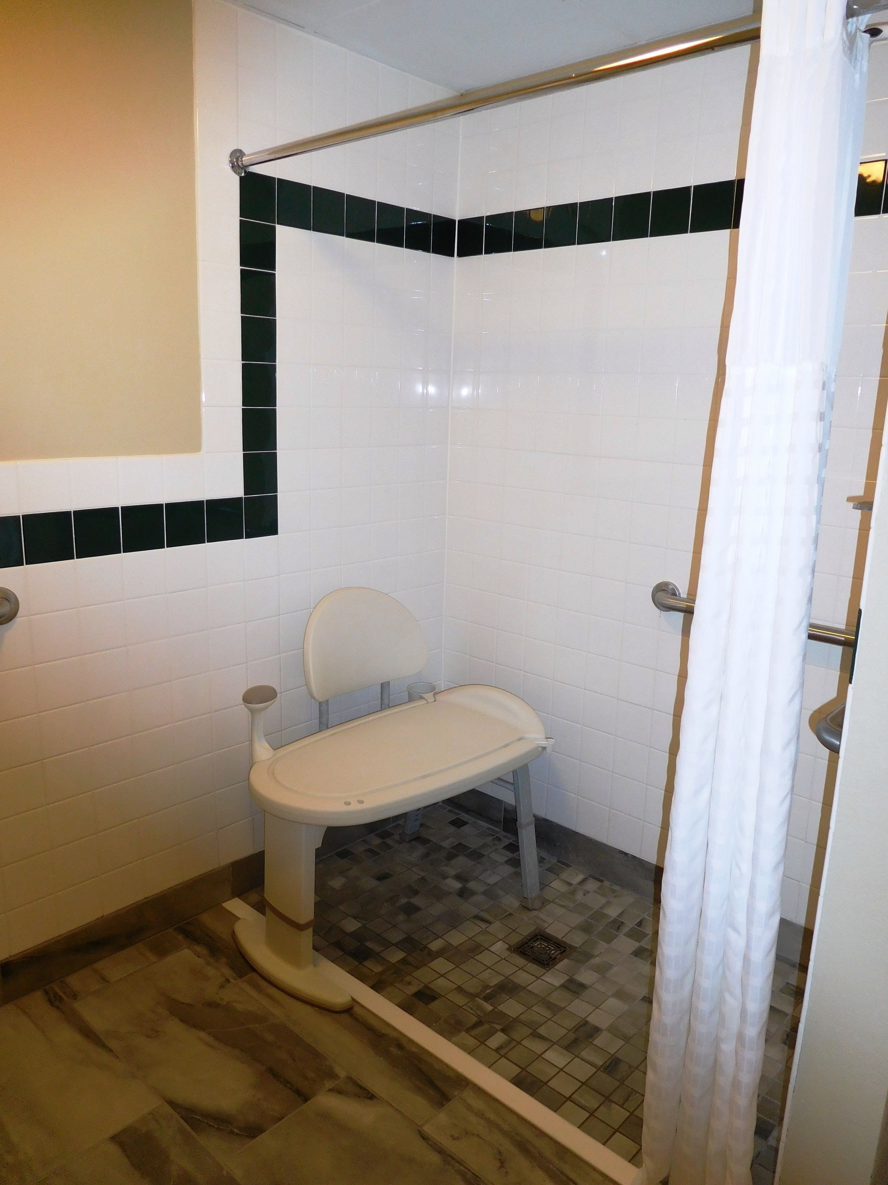 Ein Badezimmer mit Dusche, Toilette und einem kleinen Waschbecken.