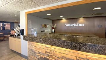 En receptionsdisk med en fasad av sten, en träram och logotypen för American Inn.
